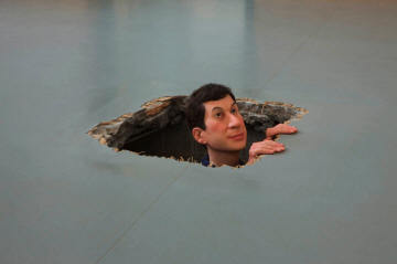  Cattelan peeking out from a hole in the floor. 